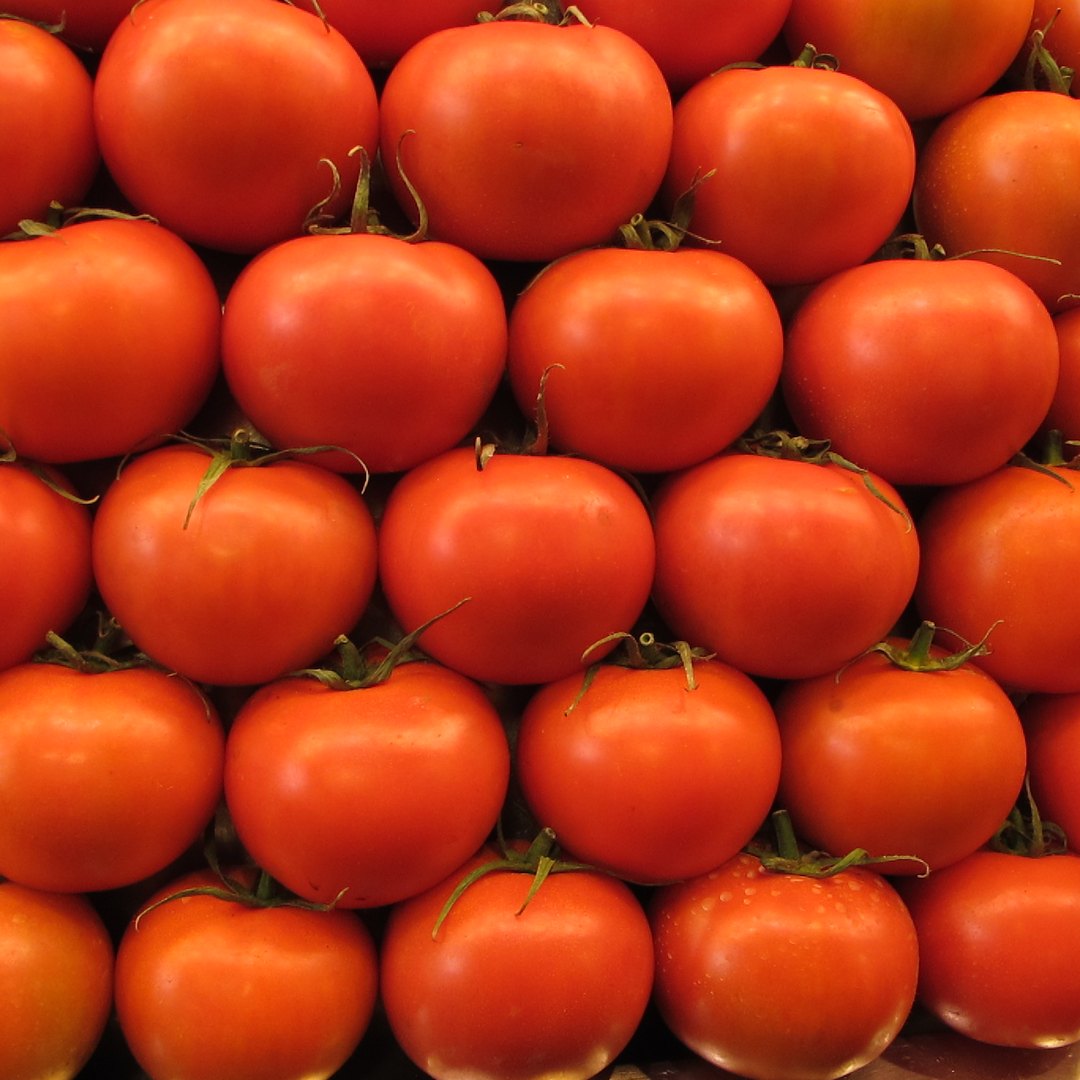 Cajón de tomates y verduras en el local